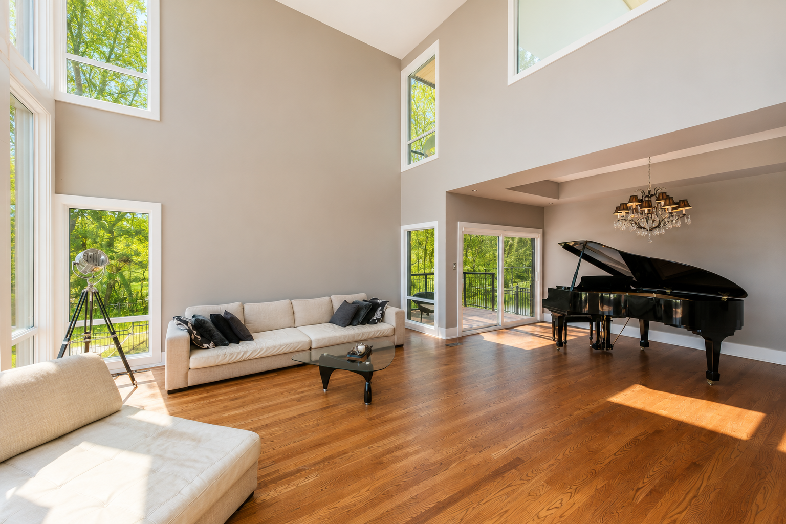 Great room seating area with grand piano and forest views